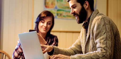 Two people reviewing a story together on a laptop